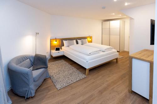 ein Schlafzimmer mit einem Bett, einer Couch und einem Sessel in der Unterkunft Alpen-Ferienwohnung Ginova in Garmisch-Partenkirchen