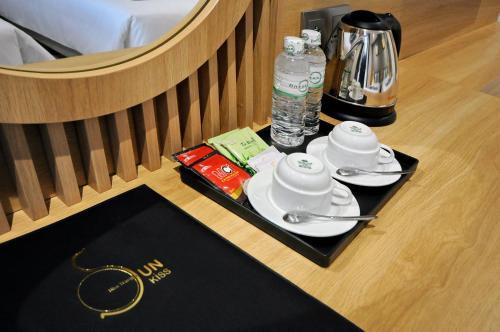a tray with cups and saucers on a table in a hotel room at Sun Kiss Hotel in Nha Trang