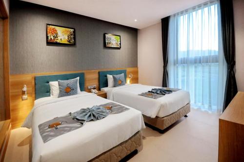 a hotel room with two beds and a window at Sun Kiss Hotel in Nha Trang