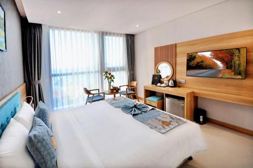 a hotel room with a bed and a table at Sun Kiss Hotel in Nha Trang