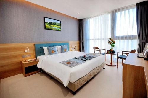 a hotel room with a large bed and a desk at Sun Kiss Hotel in Nha Trang
