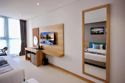 a hotel room with a mirror and a bed at Sun Kiss Hotel in Nha Trang