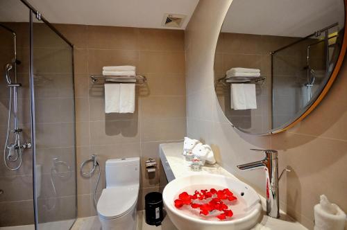 a bathroom with a sink and a toilet and a mirror at Sun Kiss Hotel in Nha Trang