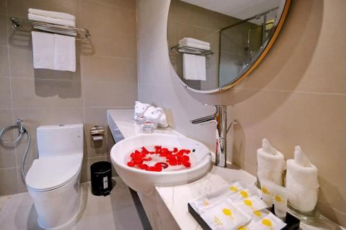 a bathroom with a sink and a toilet and a mirror at Sun Kiss Hotel in Nha Trang
