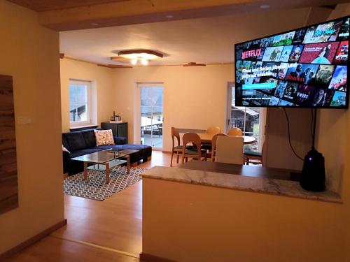 a living room with a large flat screen tv on the wall at Ferienhaus am Bach in Deuerling