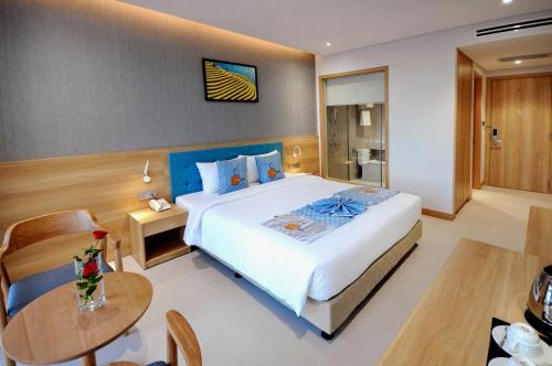 a bedroom with a large bed and a table at Sun Kiss Hotel in Nha Trang