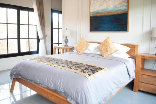 a bedroom with a large bed with a painting on the wall at Casa Narrow Villa in Nembrala