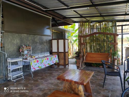 a patio with a table and a table and a bench at Angels Chambres d'hotes in Rong Sak