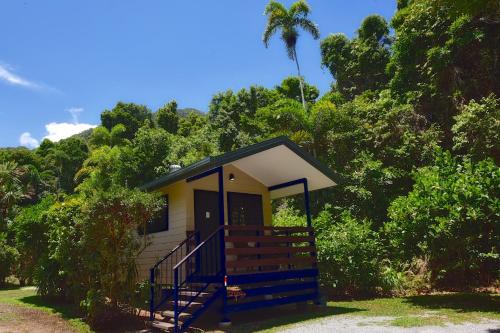 a tiny house with a porch and a staircase at Thornton Beach Bungalows Daintree in Cape Tribulation