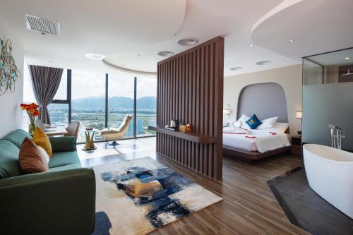 ニャチャンにあるAmber Hotel managed by HTのベッドとリビングルームがあるホテルの部屋