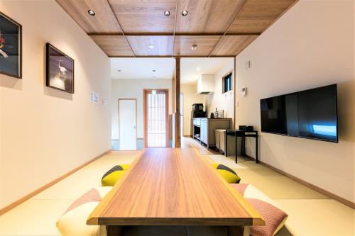 a living room with a wooden table and chairs at MUSUBI HOTEL MACHIYA Naraya-machi 2 in Fukuoka