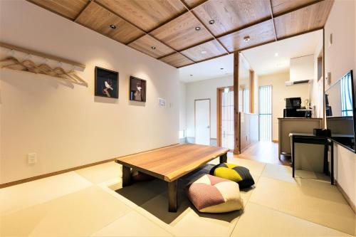 a living room with a wooden table and a couch at MUSUBI HOTEL MACHIYA Naraya-machi 2 in Fukuoka