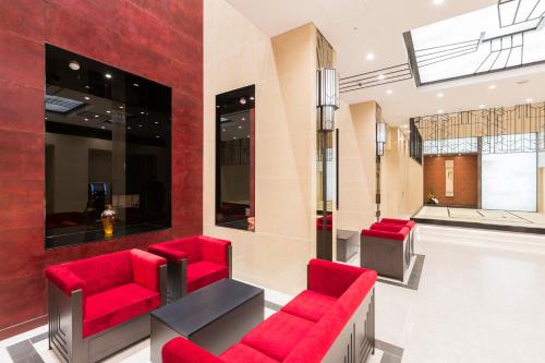 a waiting room with red chairs and a counter at Hotel Dans Le Coeur Osaka Umeda in Osaka