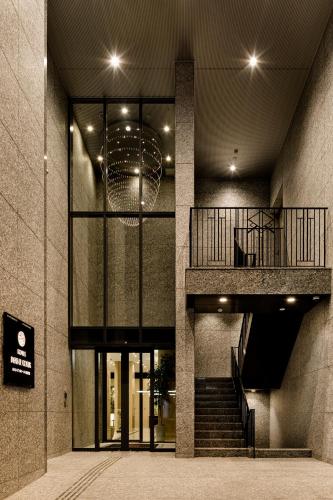 a lobby of a building with a staircase and a balcony at Hotel Dans Le Coeur Osaka Umeda in Osaka