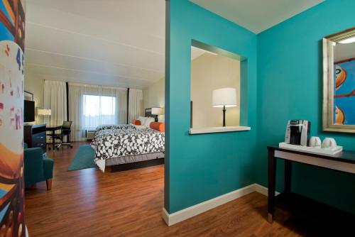 a bedroom with a bed and a blue wall at Hotel Indigo Atlanta Airport College Park by IHG in Atlanta