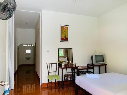 a bedroom with a bed and a desk and a television at ศรีสุภาวดีรีสอร์ท-Srisupawadee resort in Prachuap Khiri Khan