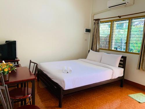 a bedroom with a bed with two candles on it at ศรีสุภาวดีรีสอร์ท-Srisupawadee resort in Prachuap Khiri Khan