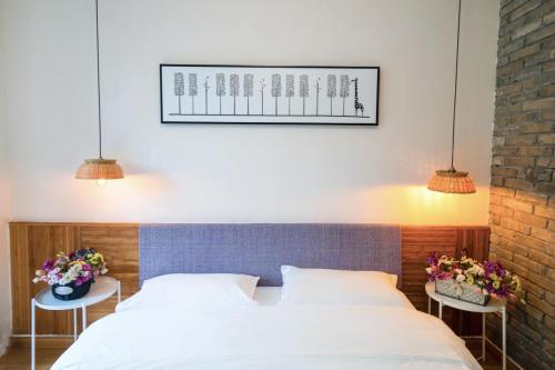 a bedroom with two beds and two tables with flowers at Xi'an Travelling with Hotel South Gate in Xi'an