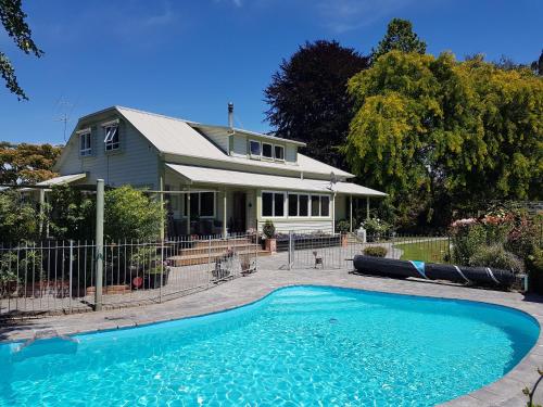 a house with a swimming pool in front of a house at The Jolly Poacher Retreat in Blenheim