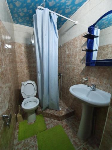 a bathroom with a toilet and a sink at Rahat Guesthouse in Dzhergalan