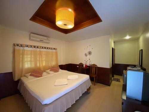 une chambre avec un grand lit et une télévision dans l'établissement Baan Rom Mai Resort, à Chaweng