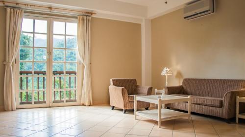 a living room with a couch and chairs and a table at Colmar Tropicale in Bukit Tinggi