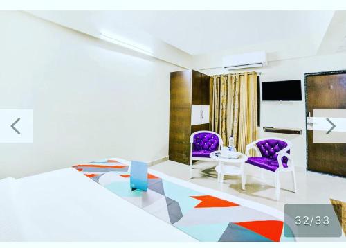 a room with two purple chairs and a table at The Paradise Aundh in Pune