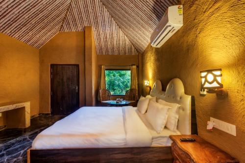 Belparāo的住宿－Lohagarh Corbett Resort，一间卧室,卧室内配有一张大床