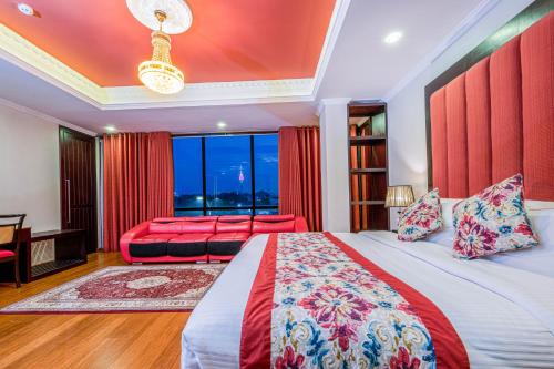 a bedroom with a bed and a desk and a window at Earl's Red Colombo in Colombo