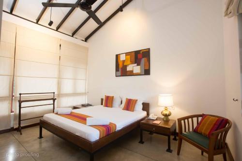 - une chambre avec un lit, une table et une chaise dans l'établissement Jaffna Heritage Villa, à Jaffna