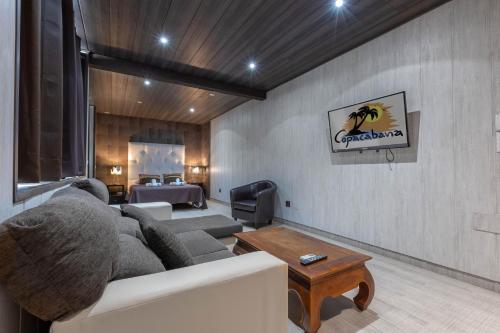 a living room with a couch and a bed at Hotel Copacabana Tarifa Beach in Tarifa