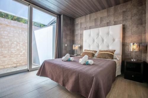 ein Schlafzimmer mit einem großen Bett mit zwei Handtüchern darauf in der Unterkunft Hotel Copacabana Tarifa Beach in Tarifa