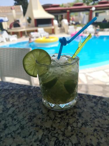 a drink sitting on a table next to a pool at Mediterranean Blue in Kavos