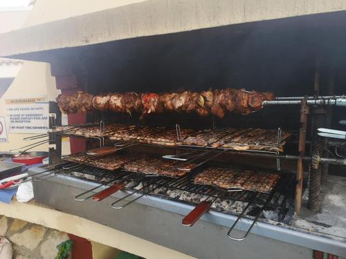 
a grill filled with lots of food on top of a conveyor belt at Mediterranean Blue in Kavos
