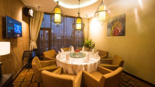 a dining room with a table and chairs and lights at Almond Hotel Bassac River in Phnom Penh