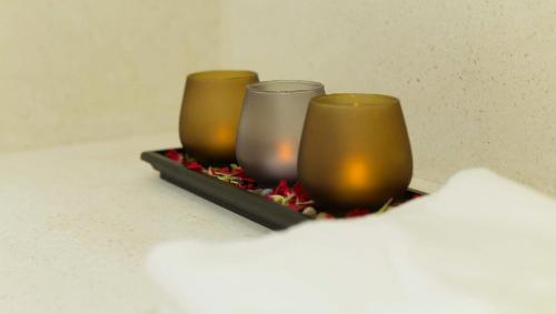 two candles are sitting on a tray with spices at Almond Hotel Bassac River in Phnom Penh