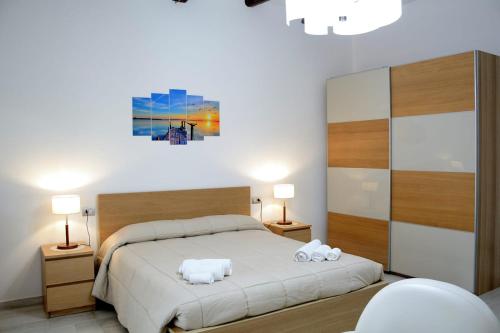 una camera da letto con un letto e due asciugamani di AL TEATRO VERDI LUXURY APARTMENT a Salerno