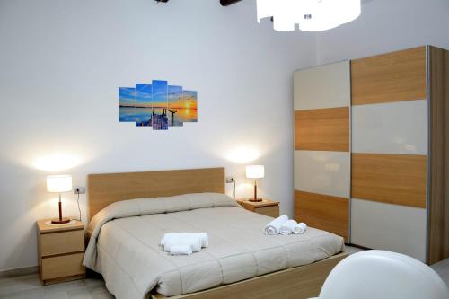 a bedroom with a bed with two towels on it at AL TEATRO VERDI LUXURY APARTMENT in Salerno