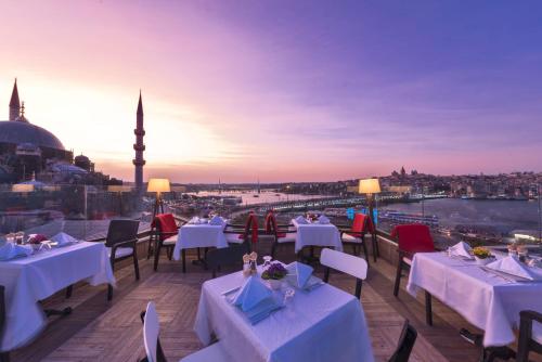 a restaurant with tables and chairs and a view of a city at Alpek Hotel in Istanbul