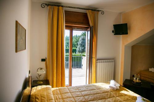 Schlafzimmer mit einem Bett und einer Glasschiebetür in der Unterkunft River Hotel in Castel di Sangro