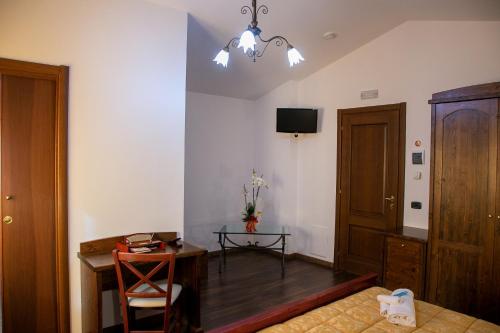 a room with a bed and a desk and a television at River Hotel in Castel di Sangro