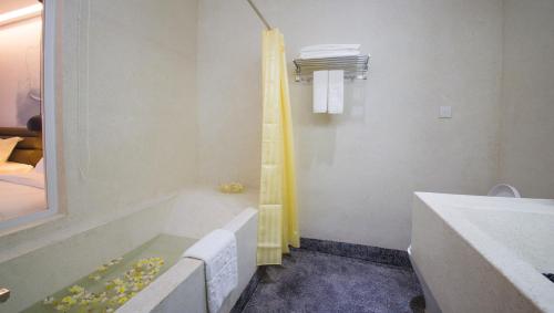 a bathroom with a bath tub and a sink at Almond Hotel Bassac River in Phnom Penh