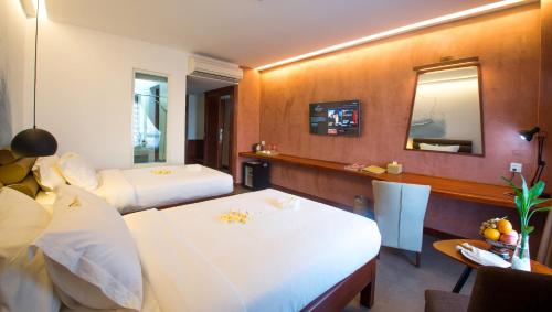a hotel room with two beds and a mirror at Almond Hotel Bassac River in Phnom Penh