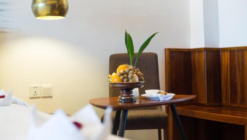 a bowl of fruit on a table in a room at Almond Hotel Bassac River in Phnom Penh