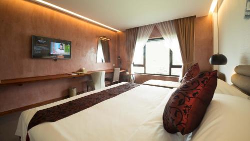 a bedroom with a large white bed in a room at Almond Hotel Bassac River in Phnom Penh