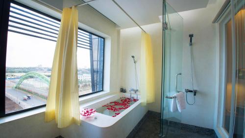 a bathroom with a shower and a window with a tub at Almond Hotel Bassac River in Phnom Penh