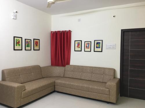 a living room with a couch and a red curtain at Grand Suites Srirangam in Tiruchchirāppalli