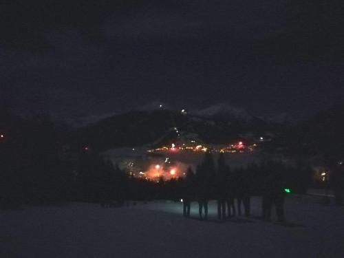 a group of people standing in the snow at night at Appartement Gipfelblick- Tiroler Zugspitze Arena in Biberwier in Biberwier