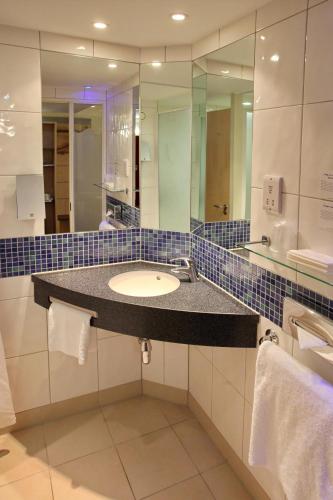 a bathroom with a sink and a mirror at Holiday Inn Express Birmingham Redditch by IHG in Redditch