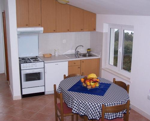 a kitchen with a table with a bowl of fruit on it at Seven Seas Apartments in Mlini
